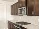 This gourmet kitchen features stainless steel appliances and sleek dark wood cabinetry at 22541 W Pontiac Dr, Surprise, AZ 85387