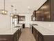 A modern kitchen with a center island, stainless steel appliances, and dark cabinets provides plenty of cooking and storage space at 22541 W Pontiac Dr, Surprise, AZ 85387