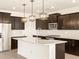 This gourmet kitchen features a large island, stainless steel appliances, and dark wood cabinetry at 22541 W Pontiac Dr, Surprise, AZ 85387