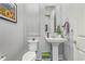 Elegant powder room with pedestal sink and white toilet at 22917 E Camina Buena Vis, Queen Creek, AZ 85142