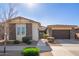 Single-story home with stone accents and a two-car garage at 22917 E Camina Buena Vis, Queen Creek, AZ 85142