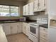 Galley style kitchen with white cabinets and appliances at 2429 E Calypso Ave, Mesa, AZ 85204