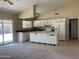 Kitchen features island, white cabinets and sliding door to patio at 2429 E Calypso Ave, Mesa, AZ 85204