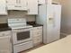 Kitchen with white cabinets, range, and refrigerator at 2429 E Calypso Ave, Mesa, AZ 85204