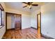 Bedroom with hardwood floors, ceiling fan, and built-in closet at 2602 S 226Th Dr, Buckeye, AZ 85326