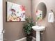 Charming powder room with pedestal sink, oval mirror, and tasteful artwork at 26783 W Piute Ave, Buckeye, AZ 85396