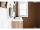 Small bathroom with white sink and cabinet, brown textured walls, and tiled floor at 3715 N 9Th Pl, Phoenix, AZ 85014