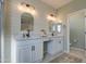 Modern bathroom with double vanity, farmhouse style mirrors, and a walk-in shower at 3740 S 182Nd Ln, Goodyear, AZ 85338