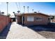 Tan house exterior with a brick walkway and partial view of the backyard at 4320 W Keim Dr, Glendale, AZ 85301