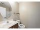 Clean bathroom with toilet, sink, and oval mirror at 44865 W Horse Mesa Rd, Maricopa, AZ 85139