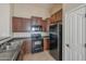 Modern kitchen with dark wood cabinets and black appliances at 44865 W Horse Mesa Rd, Maricopa, AZ 85139