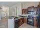 Well-equipped kitchen with dark wood cabinets and black appliances at 44865 W Horse Mesa Rd, Maricopa, AZ 85139