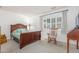 Cozy bedroom with a wooden bed frame, rocking chair, and large window with plantation shutters at 4944 E Windrose Dr, Scottsdale, AZ 85254