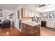 Kitchen features white cabinets, a brick breakfast bar, and a view into living room at 4944 E Windrose Dr, Scottsdale, AZ 85254