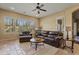 Comfortable living room featuring leather sofas and a ceiling fan at 5045 S Mingus Pl, Chandler, AZ 85249