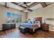 Main bedroom with wood flooring, king bed, and ceiling fan at 5045 S Mingus Pl, Chandler, AZ 85249