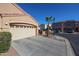 Tan house with a two-car garage and a palm tree in front, other houses visible at 7008 W Cesar St, Peoria, AZ 85345