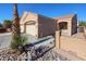 Tan house with a two-car garage and a large palm tree in the front at 7008 W Cesar St, Peoria, AZ 85345