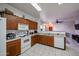 Bright kitchen with wood cabinets, white appliances, and view to living room at 7008 W Cesar St, Peoria, AZ 85345