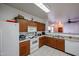 Bright kitchen with ample wood cabinets, white appliances, and a breakfast bar at 7008 W Cesar St, Peoria, AZ 85345