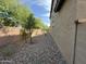 Gravel side yard with small trees and a block wall at 7309 S 17Th Dr, Phoenix, AZ 85041