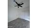 Bright bedroom with gray wood-look tile floors, ceiling fan and double door closet at 8306 W Swansea Dr, Arizona City, AZ 85123