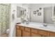 Bathroom with double sinks, oak vanity, and shower with patterned curtain at 953 E Fieldstone Pl, Chandler, AZ 85249