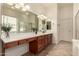 Bright bathroom featuring double vanities, a large mirror, and modern lighting at 953 E Fieldstone Pl, Chandler, AZ 85249