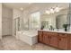 This primary bathroom includes a tub, a vanity with drawers, and a glass enclosed shower at 953 E Fieldstone Pl, Chandler, AZ 85249