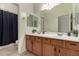 Bathroom with a double sink vanity, a large mirror, a shower with black curtain and tile floors at 953 E Fieldstone Pl, Chandler, AZ 85249