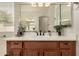 Bright bathroom featuring a wood cabinet vanity, a large mirror, and elegant decor at 953 E Fieldstone Pl, Chandler, AZ 85249