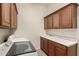 Functional laundry room featuring cabinetry, a sink, white walls, and laundry machines at 953 E Fieldstone Pl, Chandler, AZ 85249