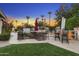 Well-appointed outdoor kitchen area with built-in grill, bar seating, and manicured lawn at 953 E Fieldstone Pl, Chandler, AZ 85249