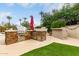 Outdoor kitchen with a built-in grill, bar, and ample counter space offers convenience for backyard entertaining at 953 E Fieldstone Pl, Chandler, AZ 85249