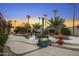 Serene pool area featuring a stone waterfall, mature palms, and colorful potted plants at 953 E Fieldstone Pl, Chandler, AZ 85249