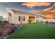 Landscaped backyard with artificial turf and a covered patio at 16541 W Edgemont Ave, Goodyear, AZ 85395
