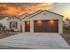 Two-car garage home with brown doors and drought-tolerant landscaping at 16541 W Edgemont Ave, Goodyear, AZ 85395