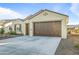 Two-car garage with light-brown doors and stone accents at 16541 W Edgemont Ave, Goodyear, AZ 85395