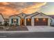 Tan two-car garage home with a landscaped front yard at 16541 W Edgemont Ave, Goodyear, AZ 85395