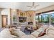 Comfortable living room featuring a stone fireplace and large windows at 18411 E Tranquilo Way, Rio Verde, AZ 85263