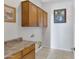 Bright laundry room with wood cabinets and tile floor at 1971 E Yellowstone Pl, Chandler, AZ 85249