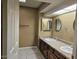 Bathroom featuring double sinks, dark wood cabinets, tiled floors, and a mirrored wall at 2121 W Union Hills Dr # 115, Phoenix, AZ 85027