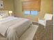 Spacious bedroom with a comfortable bed and a white armchair at 2121 W Union Hills Dr # 115, Phoenix, AZ 85027