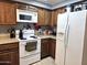 Kitchen with wood cabinets, white appliances, and granite countertops at 2121 W Union Hills Dr # 115, Phoenix, AZ 85027
