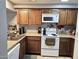 Kitchen features wood cabinets, granite countertops, and white appliances at 2121 W Union Hills Dr # 115, Phoenix, AZ 85027