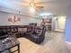 Inviting living room featuring an open layout, a ceiling fan, and a comfortable, dark leather sectional sofa at 2121 W Union Hills Dr # 115, Phoenix, AZ 85027