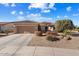 Single-story home with a two-car garage, desert landscaping, and a light-brown exterior at 21364 N Redington Point Dr, Surprise, AZ 85387