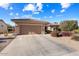 Single-story home with a two-car garage, desert landscaping, and a light-brown exterior at 21364 N Redington Point Dr, Surprise, AZ 85387