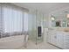Spa-like bathroom with a walk-in shower, soaking tub, and updated vanity at 23335 N Country Club Trl, Scottsdale, AZ 85255