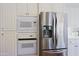 Stainless steel appliances built into white kitchen cabinetry at 23335 N Country Club Trl, Scottsdale, AZ 85255